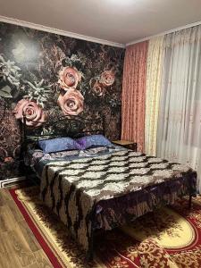 a bedroom with a bed with roses on the wall at Комната Gold Rose in Chişinău