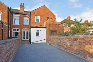 a brick alley with a white garage in a brick building at Unity House - A Stylish Haven with 3 Bedrooms, Perfect for Your Tranquil Getaway in Crewe