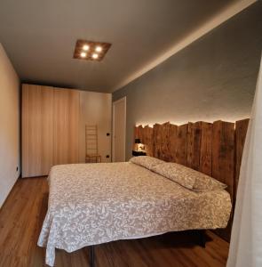 a bedroom with a bed and a wooden wall at Appartamenti il Bersaio Alloggio 2 in Sambuco