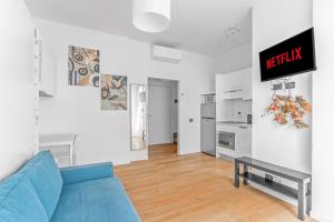 een woonkamer met een blauwe bank en een keuken bij Casa da Suite Compatta in Milaan