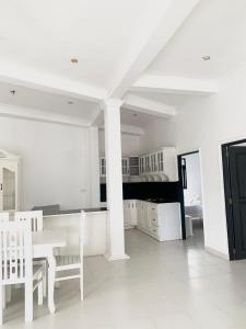 a white room with a table and chairs and a bed at Changami Residence in Nugegoda