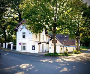 a white house on the side of a street at Historischer Gasthof Kaisermühle - Hotel & Restaurant Viersen Zentrum in Viersen