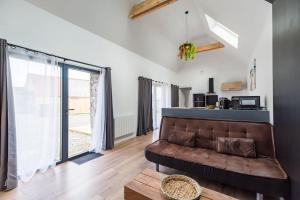 a living room with a couch and a large window at Charmante longère proche des côtes de granit rose in Lannion