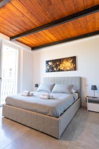 a bedroom with a large bed with a wooden ceiling at Villa San Carlo in Arona