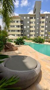 una piscina con un neumático grande frente a un edificio en JARDIM DAS PALMEIRAS II - HOME RESORT en Ubatuba