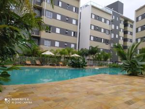 a swimming pool in front of a building at JARDIM DAS PALMEIRAS II - HOME RESORT in Ubatuba