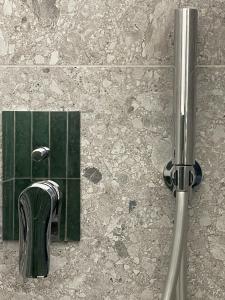 a shower in a bathroom with a green tile at MILA by The Blue Twins apartments Milano in Milan