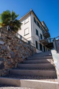 a building with stairs and a palm tree in front of it at Villa San Carlo in Arona