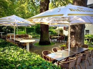 a group of tables and chairs with umbrellas at Historischer Gasthof Kaisermühle - Hotel & Restaurant Viersen Zentrum in Viersen