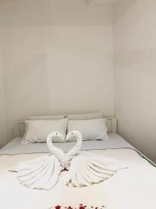 two white swans making a heart on a bed at Changami Residence in Nugegoda
