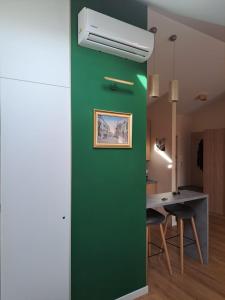 un mur vert dans une chambre avec une table dans l'établissement Apartament Ceglany - centrum, prywatne miejsce parkingowe, klimatyzacja, à Kielce