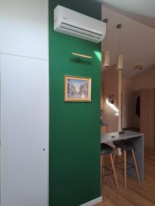 eine grüne Wand in einem Zimmer mit einem Tisch in der Unterkunft Apartament Ceglany - centrum, prywatne miejsce parkingowe, klimatyzacja in Kielce