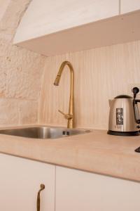eine Küche mit einer Spüle und einem Toaster auf der Theke in der Unterkunft Trullo Cinquenoci Suite in Locorotondo