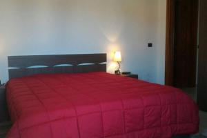 アルバタックスにあるCasa Vacanze Poseidonの赤いベッド1台(赤い毛布付)が備わるベッドルーム1室が備わります。