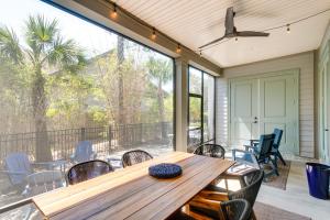 a porch with a wooden table and chairs at Luxe Jekyll Island Home with Beach and Pool Access in Jekyll Island