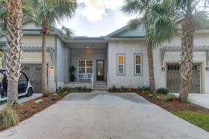 a house with palm trees in front of it at Luxe Jekyll Island Home with Beach and Pool Access in Jekyll Island
