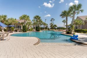 a swimming pool at a resort with palm trees at Luxe Jekyll Island Home with Beach and Pool Access in Jekyll Island