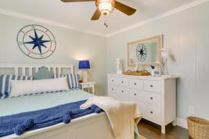 a white bedroom with a bed and a dresser at Chincoteague Apartment with Deck Walk to Waterfront in Chincoteague