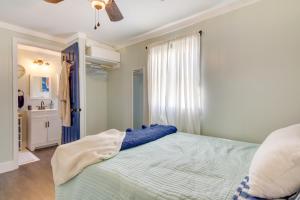 a bedroom with a blue bed and a window at Chincoteague Apartment with Deck Walk to Waterfront in Chincoteague