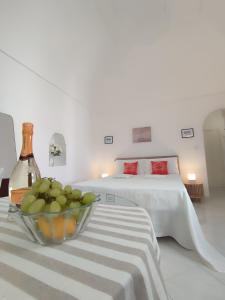 um quarto com uma cama e uma tigela de fruta numa mesa em L'Archetto romantic suite in the center of Anacapri em Anacapri