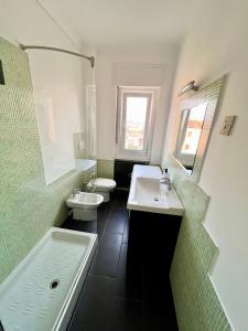 La salle de bains est pourvue de 2 lavabos, d'une baignoire et de toilettes. dans l'établissement Appartamento con vista mare e parcheggio, à Trieste