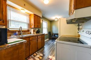 a kitchen with wooden cabinets and a white stove top oven at South Burlington Home with Seasonal Pool! in South Burlington