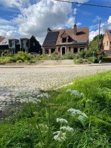 een huis met zonnepanelen aan de kant van een weg bij B&B Den Biesthoek in Grimbergen