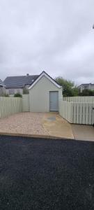 a house with a fence and a driveway at Bernie’s Place in Ballyliffin