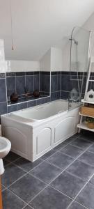 a bathroom with a white tub and a toilet at Bernie’s Place in Ballyliffin