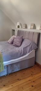 a bed with purple sheets and pillows in a bedroom at Bernie’s Place in Ballyliffin +14 photos