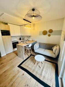 una sala de estar con un sofá y una mesa en Scorfel Lodge, Maison bleue, Terrasse, 1km mer, en Trégastel