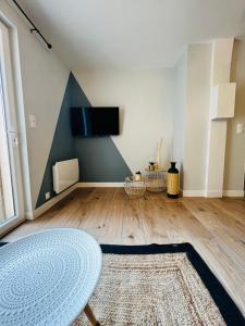 Una sala de estar con una mesa y un televisor en una pared. en Scorfel Lodge, Maison bleue, Terrasse, 1km mer, en Trégastel