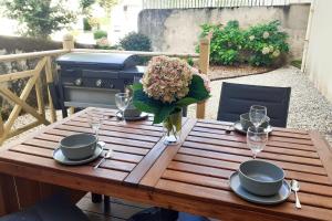 uma mesa de madeira com pratos e copos e um vaso de flores em Nice flat 300 meters away from the beach - Biarritz - Welkeys em Biarritz