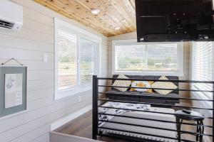 a tiny house with a crib in a room at Jasper tiny home with private hottub in Apple Valley