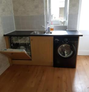 a kitchen with a sink and a washing machine at Patrick's Bar in Bangor