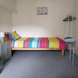 um quarto com uma cama com um cobertor colorido em Patrick's Bar em Bangor
