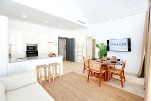 een keuken en een woonkamer met een tafel en stoelen bij Dolce Faro Niente Apartment in Faro
