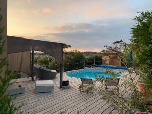 eine Terrasse mit einer Badewanne und einem Pool in der Unterkunft Chambre d’hôtes Mazet Les Abadies in Saint-Félix-de-Lodez