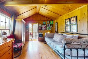 ein Wohnzimmer mit einem Sofa in einem Zimmer mit Holzwänden in der Unterkunft Sunny Serenity in Hector