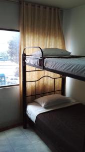 Ce dortoir comprend 2 lits superposés et une fenêtre. dans l'établissement CASA HOTEL VICTORIA Av 30, à Bogotá