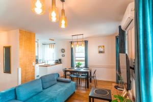 ein Wohnzimmer mit einem blauen Sofa und einem Tisch in der Unterkunft Apartament Chmielna Gold in Krakau