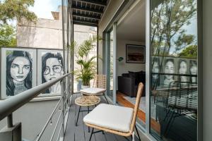 um alpendre com uma cadeira e uma mesa em New Apartments La Condesa em Cidade do México