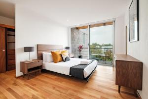 ein Schlafzimmer mit einem Bett und einem Balkon in der Unterkunft New Apartments La Condesa in Mexiko-Stadt