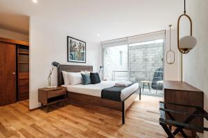 a bedroom with a bed and a desk and a window at New Apartments La Condesa in Mexico City