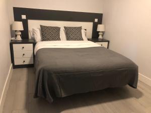 a bedroom with a large bed with two night stands at Inter - Apartamento céntrico en Alcalá de Henares in Alcalá de Henares