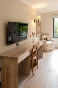 Hotel Villa el Descanso في كوريكو: غرفة معيشة مع مكتب خشبي مع تلفزيون على الحائط