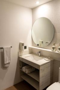 a bathroom with a sink and a large mirror at Hotel Villa el Descanso in Curicó