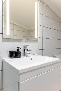 ein Badezimmer mit einem weißen Waschbecken und einem Spiegel in der Unterkunft Zhytomyr palace mimino in Schytomyr