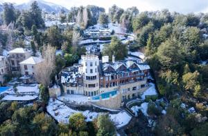 an aerial view of a mansion in the mountains at El Faro Boutique Hotel & Spa by DON in Villa La Angostura