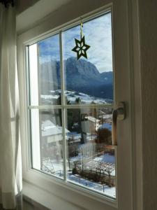 ein Fenster, an dem ein Stern hängt. in der Unterkunft Gasthof Albergo Kreuzwirt in Völs am Schlern